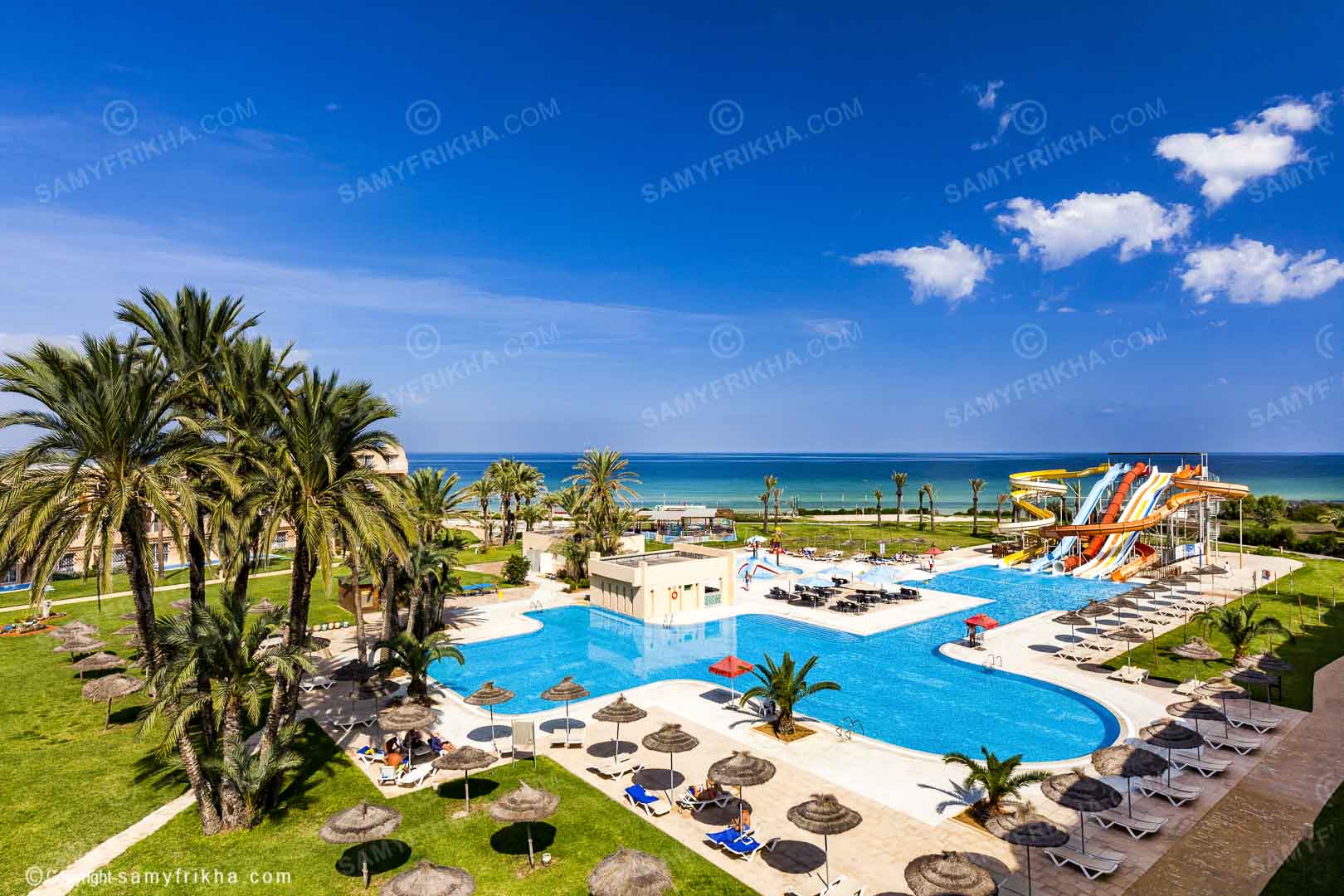 Piscine d'hôtel avec toboggans aquatiques et espaces de loisirs.