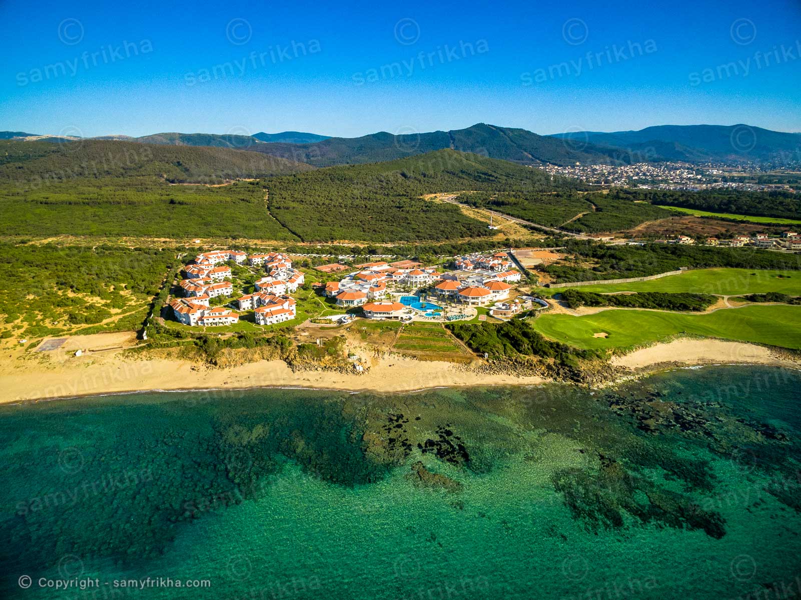 Vue d'ensemble d'un complexe hôtelier installé en bord de mer.