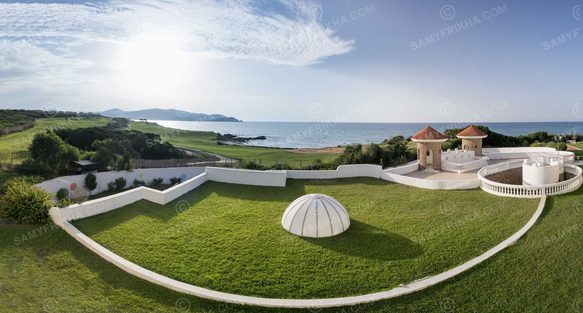 Jardins paysagers d'un hôtel en bord de mer photographiés depuis les airs.