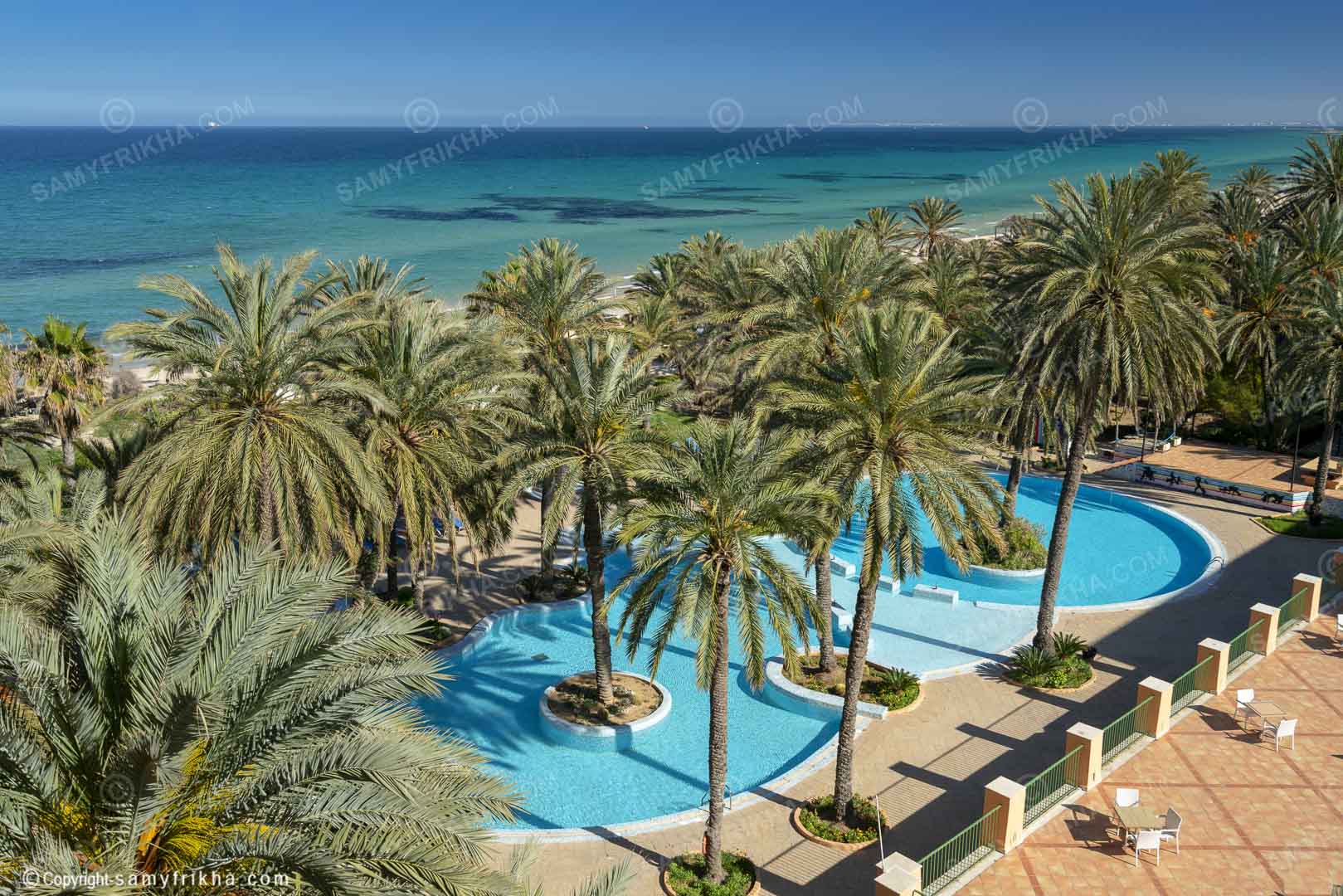 Vue d'ensemble d'un complexe hôtelier avec plusieurs piscines et jardins.