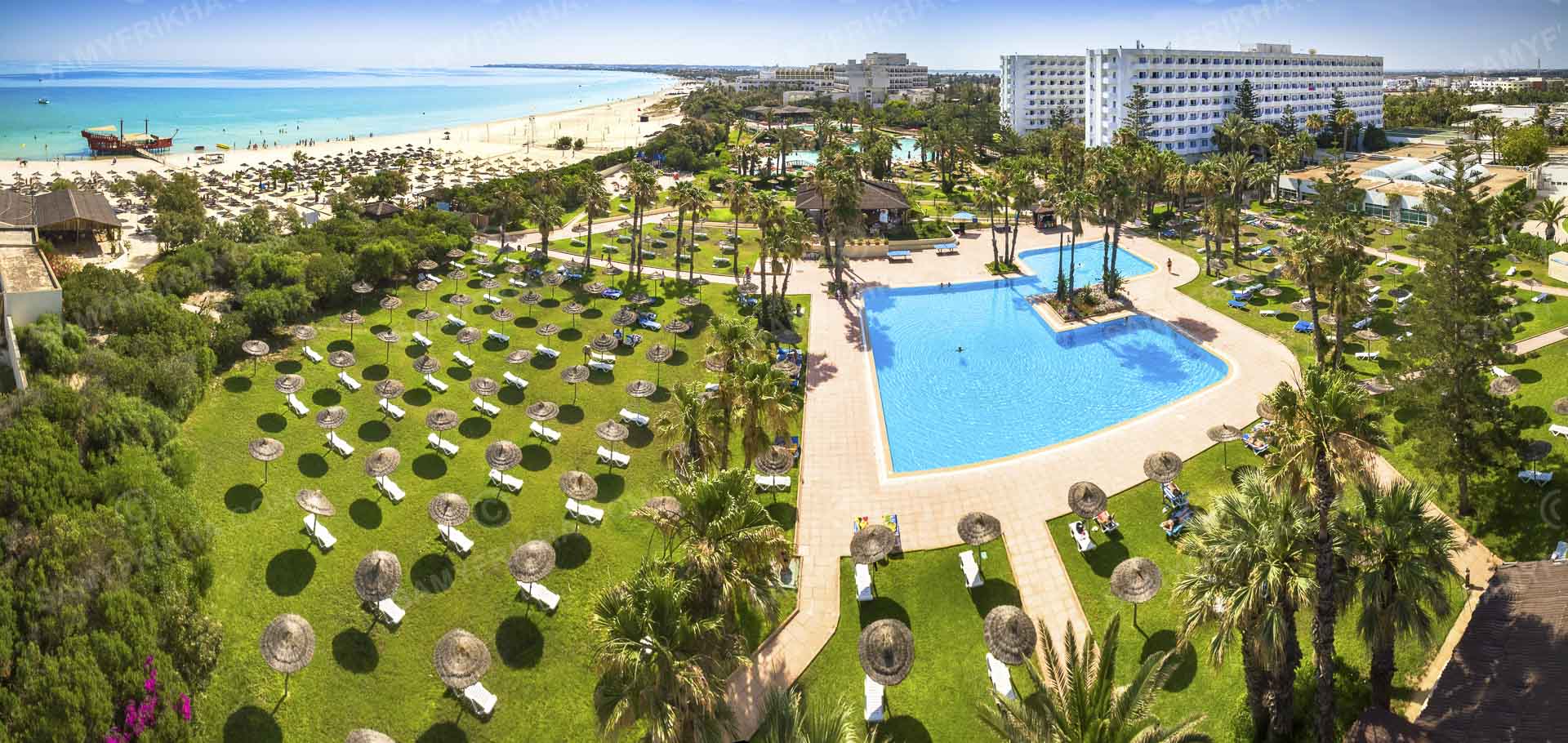 Vue aérienne des jardins, piscines et espaces extérieurs d'un hôtel.