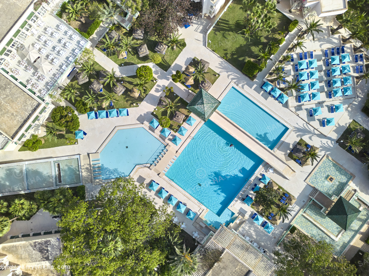 Vue aérienne des piscines et des espaces extérieurs d'un complexe hôtelier.